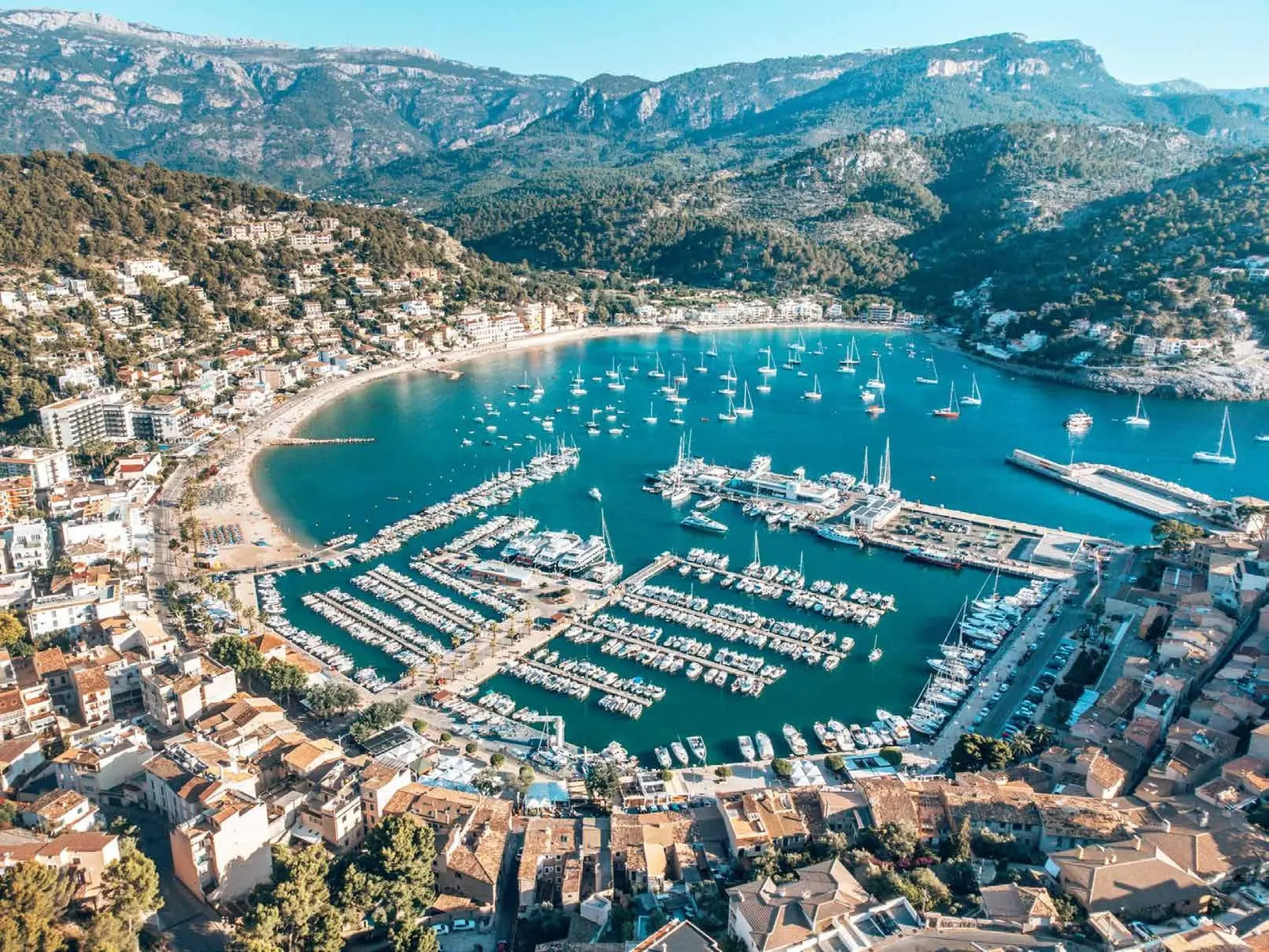 Aerial view of a Mallorca harbor surrounded by buildings and mountains