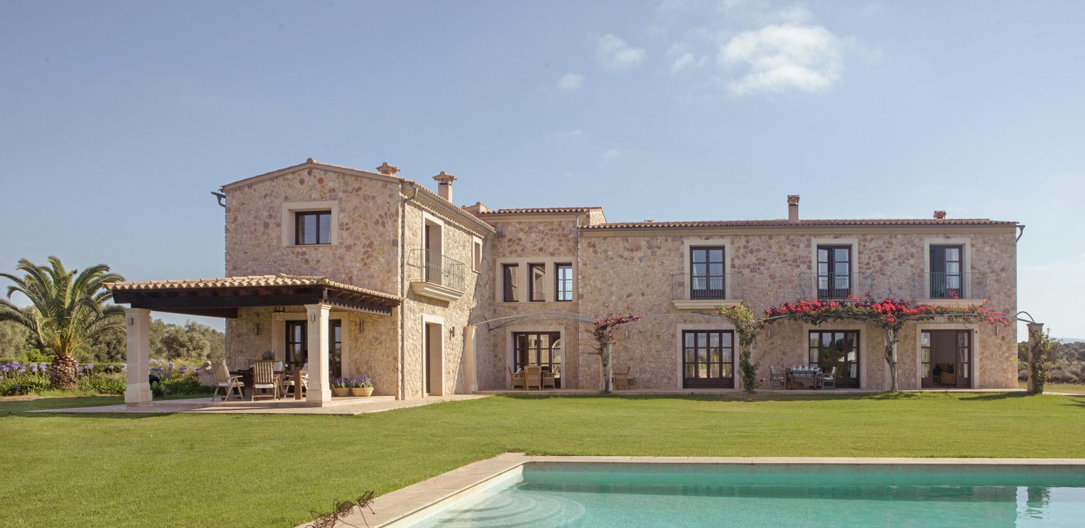 Stone residence with a lawn and swimming pool