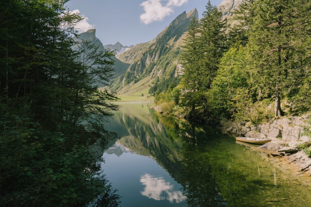 Mountain lake reflecting trees and steep slopes