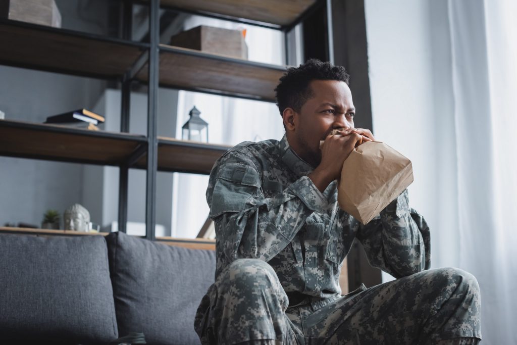 man in military uniform seeming to experience PTSD symptoms