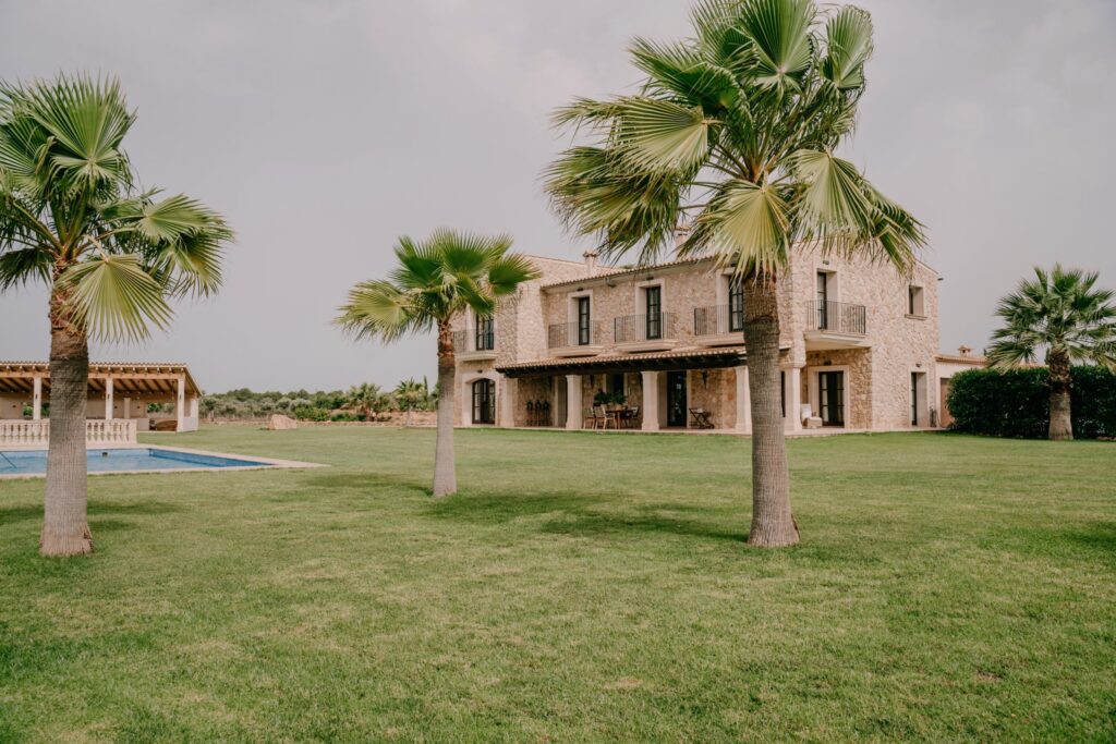 Stone residence with a lawn and palm trees at Campo Gran in Mallorca