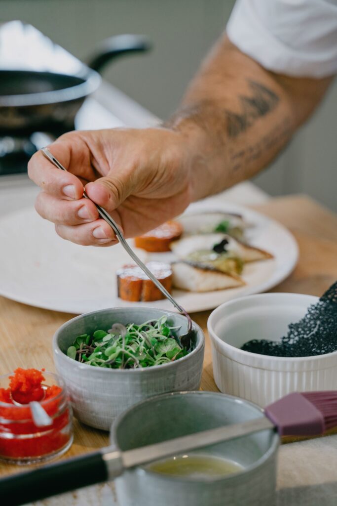 Chef garnishing a plate of food