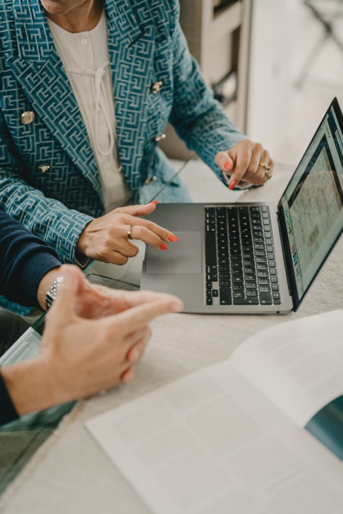 Two people discussing information on a laptop