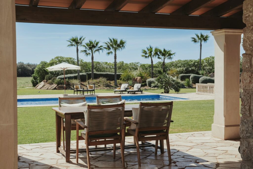 Outdoor dining table overlooking a swimming pool and garden