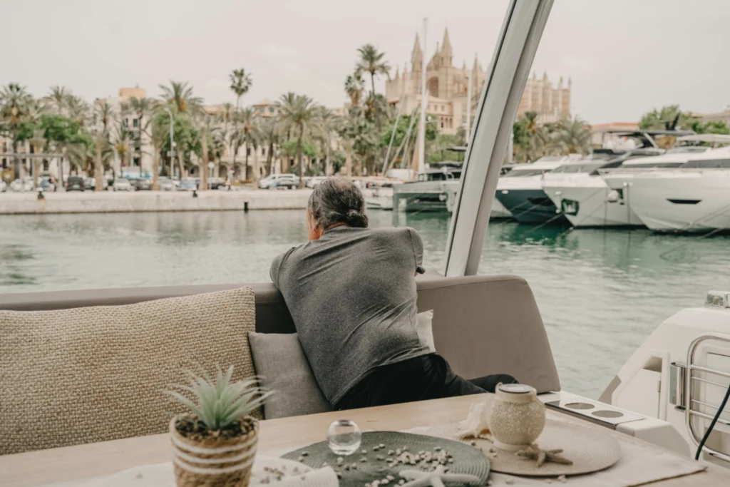 Person relaxing on a yacht overlooking a marina and a cathedral